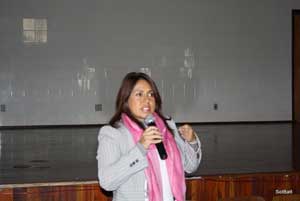 Na foto, uma mulher jovem, de cabelos médios e lisos, Dra. Scheila Lima da Secretaria da Saude  do RS fala ao microfone.